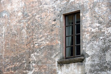window with metal bars in an old stone house in Italy