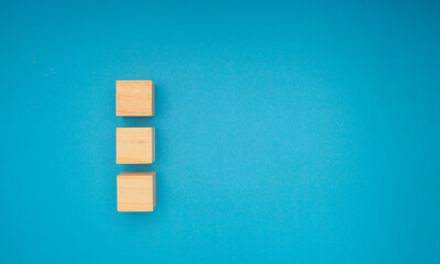 Three wooden cubes are on a blue background.