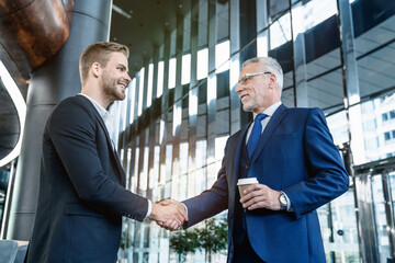 Business people meeting in a modern cafe with a handshake. Handshaking between male business...