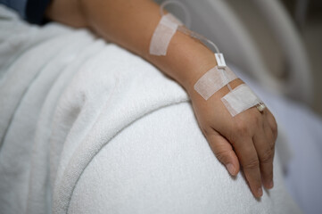 Fototapeta premium Closeup hands asian woman lying sick injections, blood, and healthcare in hospital.