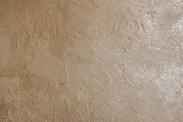 abstract background of embossed plastered wall painted metallic bronze close up