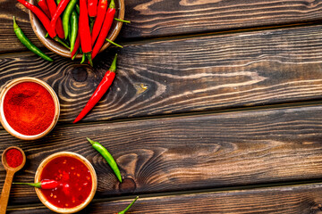 Fresh and powdered red and green chilli pepper pattern on wooden table background top view space for text