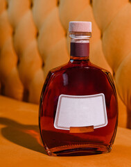 elite cognac or brandy bottle on yellow textured background