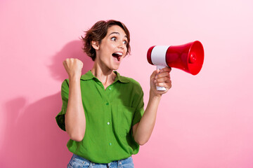 Photo portrait of pretty young girl raise fist celebrate shout megaphone wear trendy green outfit...