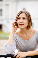 Young happy woman calling by phone on the street