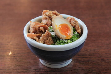 A steaming bowl of ramen featuring perfectly marinated pork belly nestled amongst springy noodles, crowned with a soft-boiled egg.