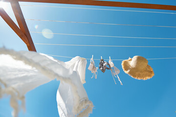 White woman  bikini swimsuit hanging air drying on line in summer sunny windy day. Swimwear, pareo...