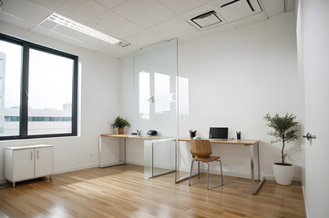 Fototapeta premium Minimalist office space with ample natural light, wooden desk, and comfortable seating