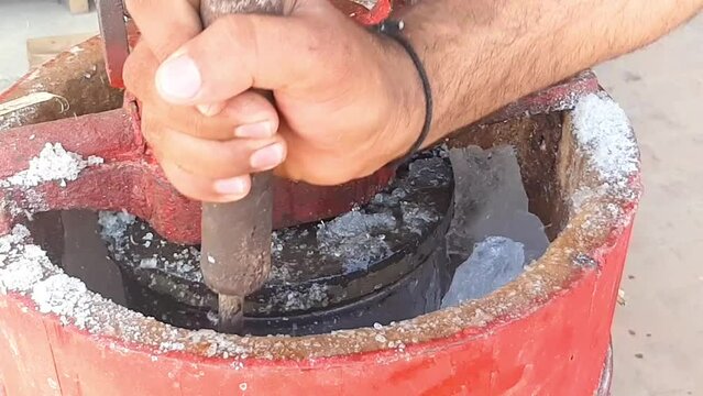 Slow Motion Footage A Man puts ice on an ice cream machine and breaks it. How to make Qulfa. Manual kulfa making machine in pakistan. The breaking of the ice. Beautiful 4K footage. 