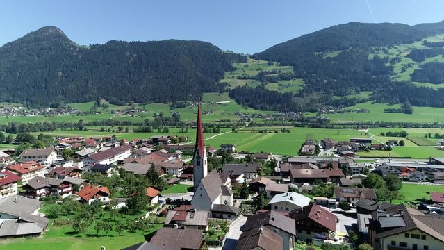 Aerial view moving towards Pfarrkirche located in Schlitters a small town in Zillertal valley in Austria near the strongly glaciated section of the Alps also most visited by tourists in the area 4k