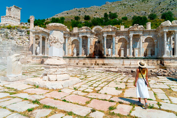 Ancient City of Sagalassos, Woman looking at the statues next to the Antonine Fountain in the ....