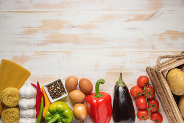 Colorful vegetables and spaghetti on wooden background with copy space.