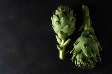 Ripe organic artichokes on a dark background. Vegetable concept.