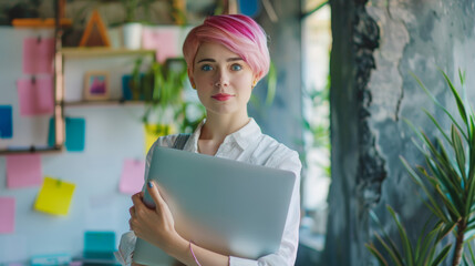 Modern Office: Portrait of Beautiful Authentic Specialist with Short Pink Hair Standing, Holding Laptop Computer, Concentrated on Her Work. Working on Design, Data Analysis, Plan Strategy Stock Photo 