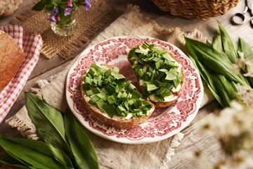 Green wild garlic or ramson leaves on a two slices of sourdough bread