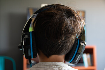 Chico con auriculares juega video juegos o escucha música