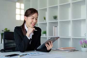 Businesswoman in office using tablet computer, audit documents and financial analysis, business people concept