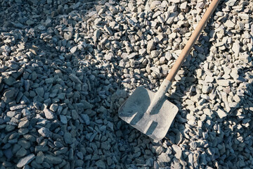 Metal Shovel on Gravel Stones. Rusty Square Shovel digging Gravel pile at construction site. Close up of gravel pile on a construction site for road building