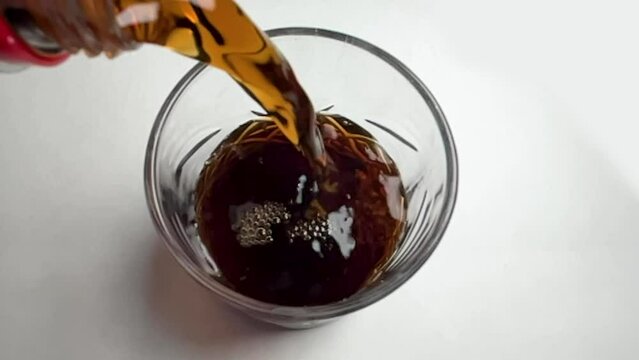 slow motion shot of pouring cola into glass, soda in a glass, soft drink, soda pop, carbonated beverage