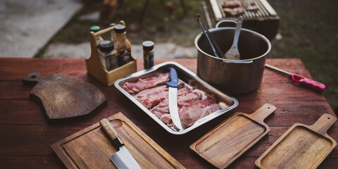 A raw meat in a tray preparation for a family outdoors dinner steak party or campfire vacation or...