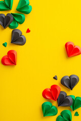 Juneteenth-inspired top view vertical photograph: hearts in red, green, black on yellow, a powerful...