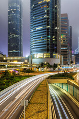 Traffic with streets and skyscrapers at night portrait format in city of Hong Kong, China