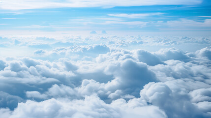 Fototapeta premium The sky is filled with fluffy white clouds, creating a serene and peaceful atmosphere. The clouds are scattered throughout the sky, with some closer to the ground and others higher up