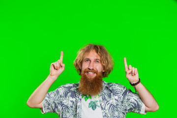 Young man showing thumbs up and pointing empty place over head, advertising area for commercial text, copy space for goods promotion advertisement. Guy isolated on chroma key background. Lifestyles