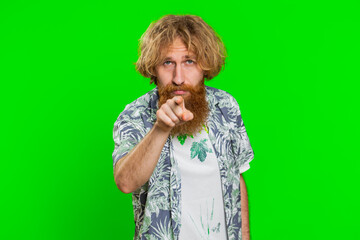 Hey you. Young happy man smiling excitedly and pointing forward to camera, choosing lucky game winner, indicating to awesome you, promotion. Redhead bearded guy isolated on green chroma key background