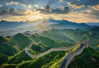The Great Wall of China is visible against the backdrop of green mountains and sky at sunset, with sunlight shining on it. - Powered by Adobe