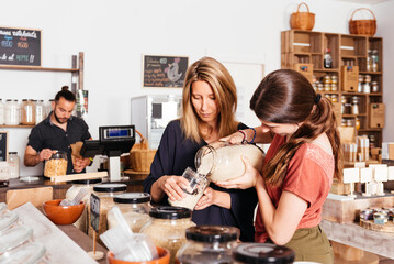 Mother and Daughter Selecting Bulk Rice at Eco-Friendly Grocery Store
