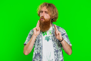 Young bearded man pointing around with finger gun gesture, looking confident making choice shooting...