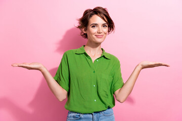 Photo portrait of pretty young girl palms compare empty space wear trendy green outfit isolated on...