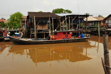 rusty valve stilt house river view lush greenery cloudy sky tropical landscape