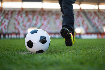 Soccer ball and legs of young player before kicking the ball