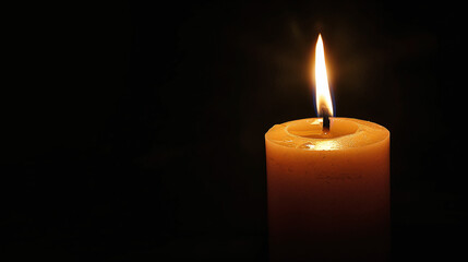 Glowing Single Candle with Bright Flame on Dark Background Symbolizing Hope and Remembrance