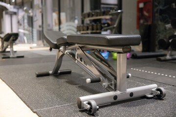 A bench is in a gym with a black and silver color