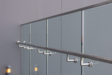 A railing with a glass railing and a silver pole