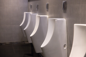 A row of urinals are lined up in a public restroom