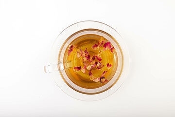 Tea made from tea rose petals in a glass bowl on white background