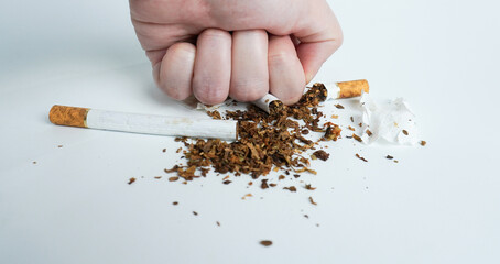 Hand fist crushing broken ripped apart cigarette filter objects isolated on horizontal ratio...