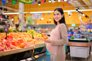 Beautiful pregnant woman shopping healthy food at grocery shop