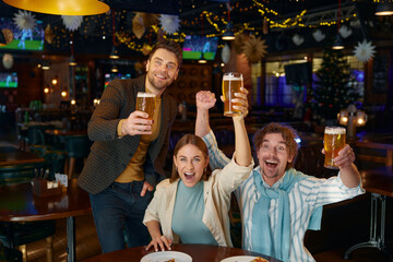 Excited friends crazy screaming supporting soccer team watching match at sports bar