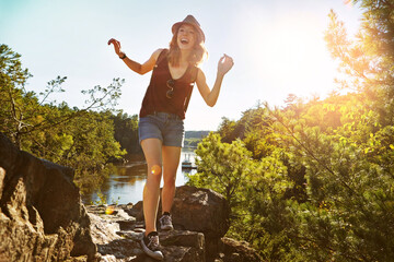 Hiking, laughing and woman in nature with lake for adventure, trekking and freedom outdoors. Morning, mountain and happy person for travel, walking and exercise on holiday, journey and vacation