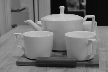 Black And White Photo Of Tea Cups And Tea Pot