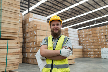 Portrait of male warehouse worker working in wooden warehouse storage. Male construction worker at...