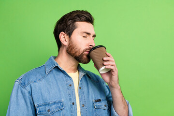Photo of dreamy positive guy dressed jeans shirt drinking beverage closed eyes empty space isolated...