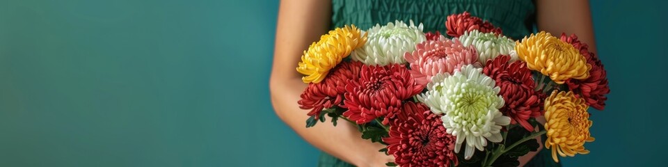 A woman hands gently hold a vibrant bouquet of chrysanthemums