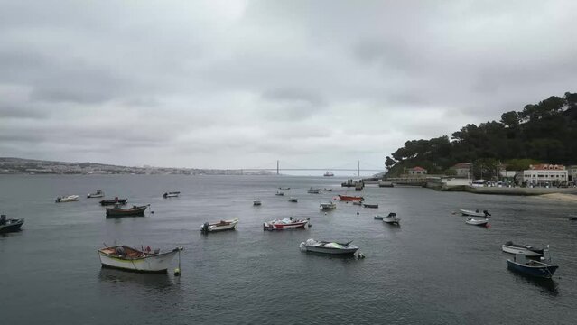 Spectacular drone footage of Trafaria Silopor Harbor captures vibrant maritime activity. Cargo ships unload against the charming coastal town backdrop. Perfect for travel and maritime projects.
