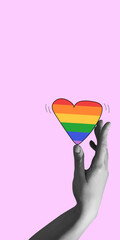 Hand gently holding vibrant rainbow heart, representing the LGBTQ community against pink background. Contemporary art collage. LGBT, equality, pride month, support, love, human rights concept
